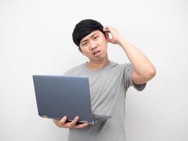 asiatischer mann, der laptop-geste hält, gelangweilt, blick in die kamera foto