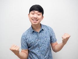 Geste des blauen Hemdes des asiatischen Mannes befriedigen glückliche Gefühle und Faust hoch foto