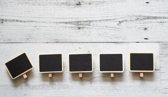 Fünf kleine Clip-Tafel-Array-Linie auf weißem Holztisch Naturschatten unter Raum, Idee-Schild-Konzept foto