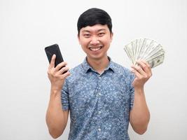 Mann fröhliches Lächeln mit Handy und viel Geld in der Hand foto