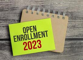 Open Enrolment 2023 Wortlaut auf einem grünen Aufkleber und Notizblock foto