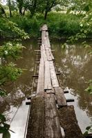 alte Holzbrücke, Holzbrücke über einen kleinen Fluss, Brücke mit der Natur. foto