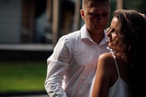 Porträt einer fröhlichen Frau und eines Mannes, die gemeinsam Zeit im Freien verbringen, sich auf der Sommerterrasse küssen, umarmen und lachen, ein verliebtes Paar am Valentinstag foto