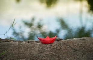 rotes Papierboot oder Origami mit Natur foto