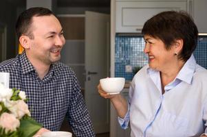 söhne gratulieren mama zum urlaub. mutter und sohn unterhalten sich bei einer tasse tee. Feiertagsfeier. 8. März, Geburtstag foto