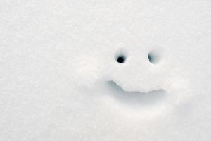 Smiley an einem Wintertag auf den Schnee gemalt. Platz kopieren. Ansicht von oben. foto