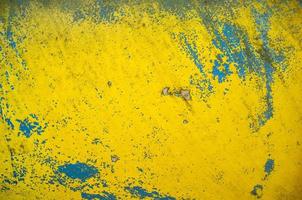 alte wand mit zerkratzter, abblätternder blau-gelber farbe. abstrakter strukturierter Hintergrund. Platz kopieren. foto