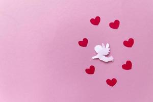 Valentinstag Konzept. rote Herzen und Amor, die im Herzen auf rosa Hintergrund zielen. valentinstag karten. foto