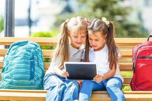 bildung, grundschule, lernen, technologie und personenkonzept - gruppe von schulkindern mit tablet-pc-computer, die spaß in der pause haben foto