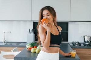 frische Orangen. junge europäerin ist drinnen in der küche drinnen mit gesundem essen foto