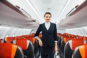 leere Plätze. junge Stewardess über die Arbeit im Passagierflugzeug foto