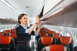 leere Plätze. junge Stewardess über die Arbeit im Passagierflugzeug foto