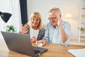 Online-Gespräch führen. Senior Mann und Frau sind zusammen zu Hause foto
