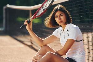 Blick in die Kamera. Tennisspielerin ist tagsüber auf dem Platz foto