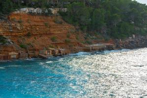 Cala Salada und Saladeta in San Antonio Abad auf den Balearen in Spanien. Langzeitbelichtung, typisches Haus für Fischerboote und Felsen. foto