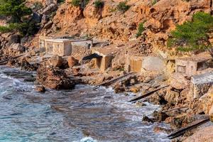 Cala Salada und Saladeta in San Antonio Abad auf den Balearen in Spanien. Langzeitbelichtung, typisches Haus für Fischerboote und Felsen. foto