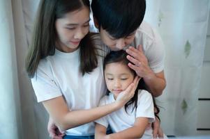 Familienurlaub, Vater und Mutter helfen der Tochter beim Klavierunterricht foto