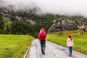 Wanderer mit Rucksack mit Blick auf Berge, Alpenblick, Mutter mit Kind foto