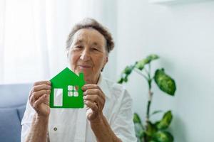 Seniorin hält den Grundriss des Hauses in ihren Händen foto