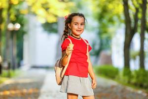 glückliches kleines Schulmädchen mit Eis. zurück zur Schule im Freien foto