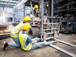 Arbeiterinnen verbieten Frachtfahrern aufgrund eines Unfalls die Weiterfahrt, das Bein eines männlichen Arbeiters bleibt im Rad eines Gabelstaplers stecken, während er in einem Autoteilelager arbeitet. foto