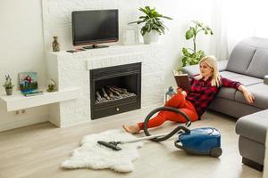 Frau Reinigung Bodenstaubsauger im modernen weißen Wohnzimmer foto