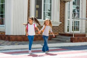 Grundschüler beim Überqueren der Straße foto