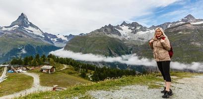 Wandern in den Schweizer Alpen mit Blumenfeld und dem Matterhorn-Gipfel im Hintergrund. foto