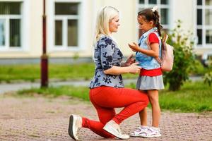 junge mutter führt ihre tochter zur schule. foto