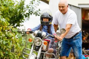 Glücklicher Großvater und seine Enkelin in der Nähe des Fahrradlächelns foto