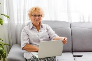glückliche reife ältere geschäftsfrau mittleren alters, die aufgeregt ist, indem sie gute nachrichten liest, die auf den laptop schauen, frohe ältere ältere dame, die zuschaut, wie sie den online-gebotswettgewinn feiert oder das siegkonzept des großartigen ergebnisses feiert foto