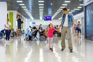 vater und kleine tochter, die auf dem flughafen spazieren gehen, familienreise foto