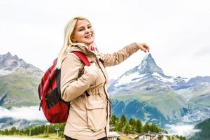 schöne junge frau, die in den schweizer alpen mit dem berühmten berg matterhorn im hintergrund wandert. foto