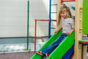 attraktives kleines Mädchen auf Spielgeräten im Freien foto