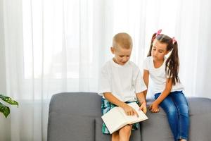 Kinder lesen zu Hause ein Buch foto