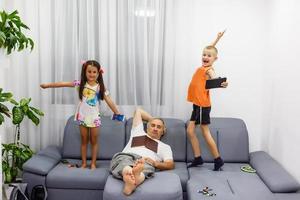 Kinder spielen mit Ihrem Smartphone, während der Großvater schläft foto