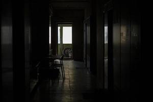 Innenbeleuchtung vom Fenster. dunkler Korridor und Licht am Ende. Reflexion auf dem Boden. foto
