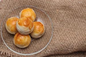 chinesisches essen mondkuchen oder chinesisches gebäck serviert auf einer glasplatte auf einem hellbraunen holztisch. foto