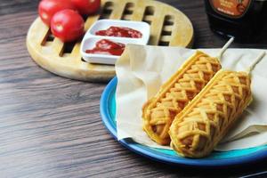 Waffelsticks Corn Dogs Hot Dog Waffeln auf einem Stock Ketchup auf einem Holztisch foto