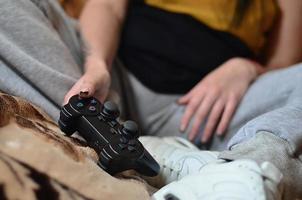 Ein junges Mädchen spielt Videospiele mit einem schwarzen Joystick mit vielen b foto