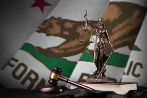 kalifornien us-staatsflagge mit statue der dame justiz, verfassung und richterhammer auf schwarzem drapierung. Begriff von Urteil und Schuld foto