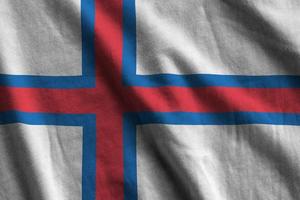 Flagge der Färöer-Inseln mit großen Falten, die im Innenbereich unter dem Studiolicht wehen. die offiziellen symbole und farben im banner foto
