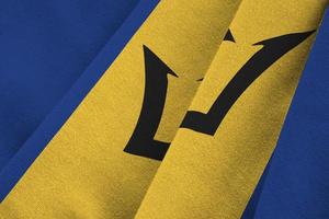 barbados-flagge mit großen falten, die unter dem studiolicht im innenbereich wehen. die offiziellen symbole und farben im banner foto