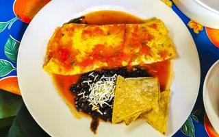 mexikanisches Omelett Eier schwarze Bohnen Kartoffeln Nachos auf weißem Teller. foto