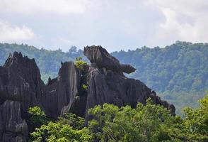 erstaunlicher Steinfelsen auf Hügel und grüner Berg schöner Hintergrund foto