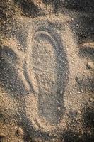 Schuhspur auf Sandabdruck Fußabdruck auf Bodenspuren von Fußtexturhintergrund foto