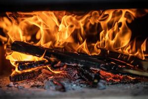 brennendes brennholz im kamin hautnah. in einem brennenden Wald foto