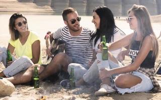 sommer, ferien, urlaub, musik, fröhliches menschenkonzept - gruppe von freunden mit gitarre, die spaß am strand haben foto