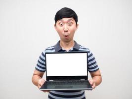 junger mann erstaunte emotion, die den weißen bildschirm des laptops isoliert hält foto