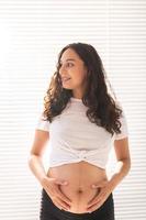 schwangere frau, die ihren bauch berührt. Schwangerschaft und Mutterschutz foto